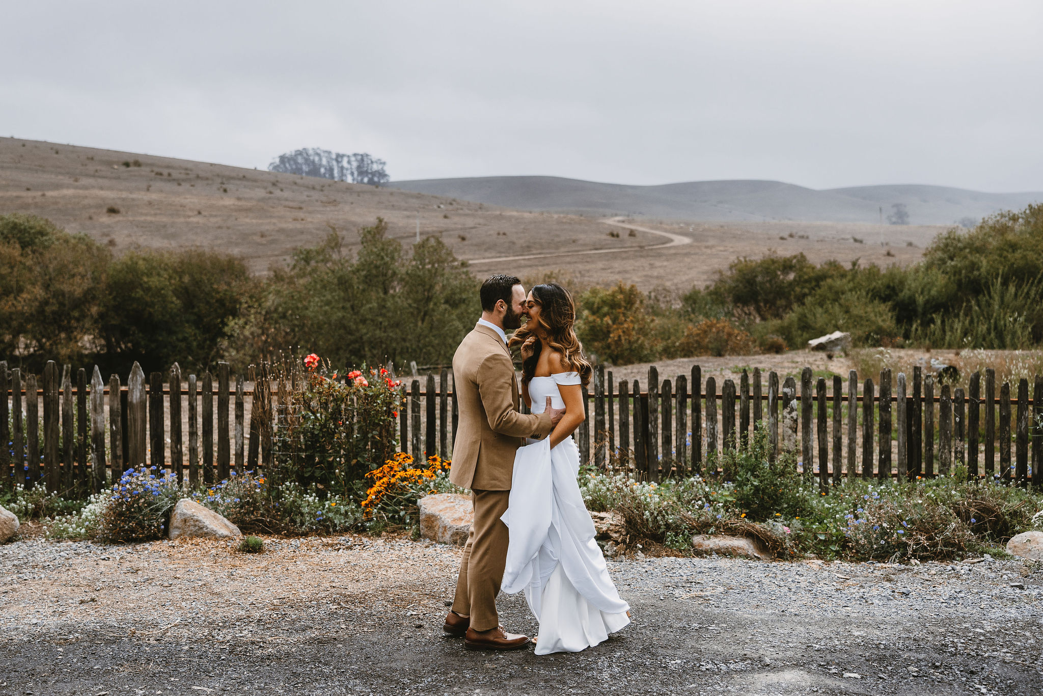Bride and groom share a joyful embrance amist the rolling hills during first look at stemple creek ranch
