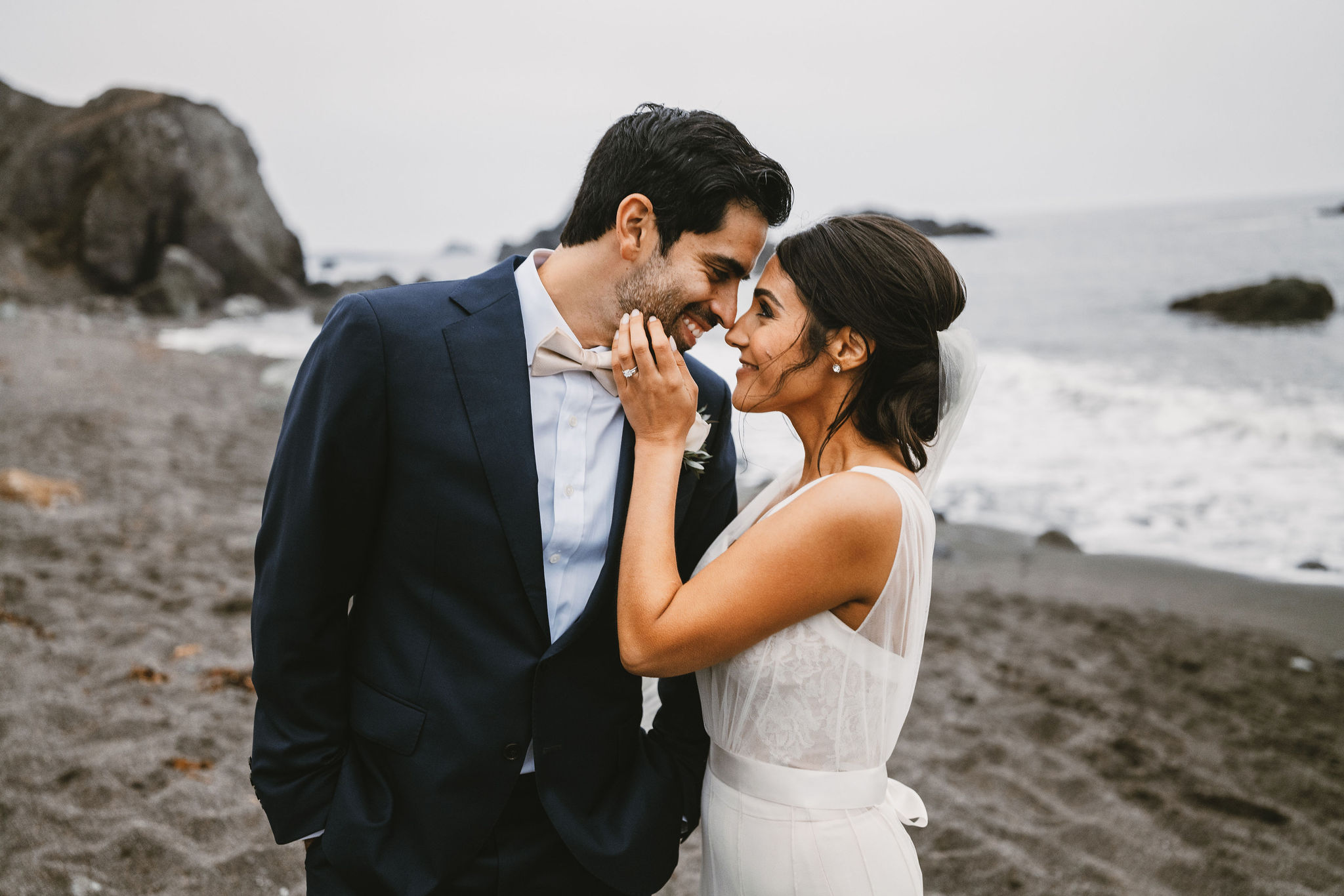 bride and groom share a love glance on the beach during a coastal elopement