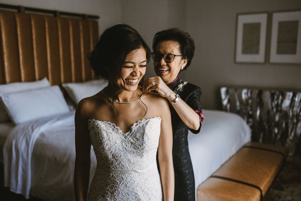 bride with mother helping her put on a necklace in san jose california