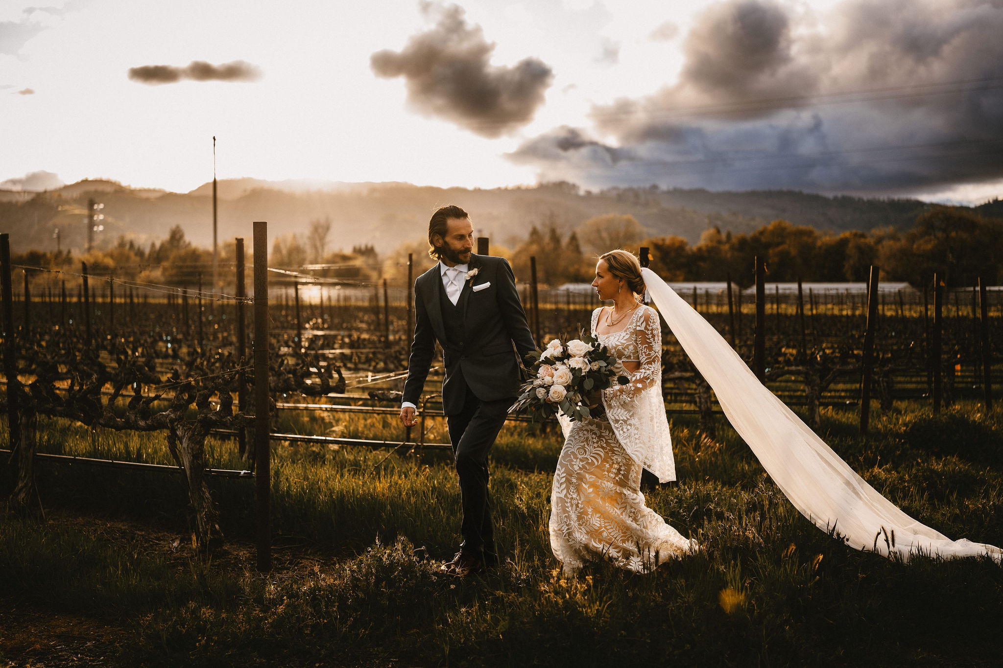 Bride and groom walking in the vineyards at Tre Posti in Napa, CA after rainstorm