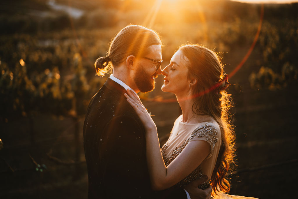romantic sunset portrait with lens flare at leal vineyards in hollister, california.