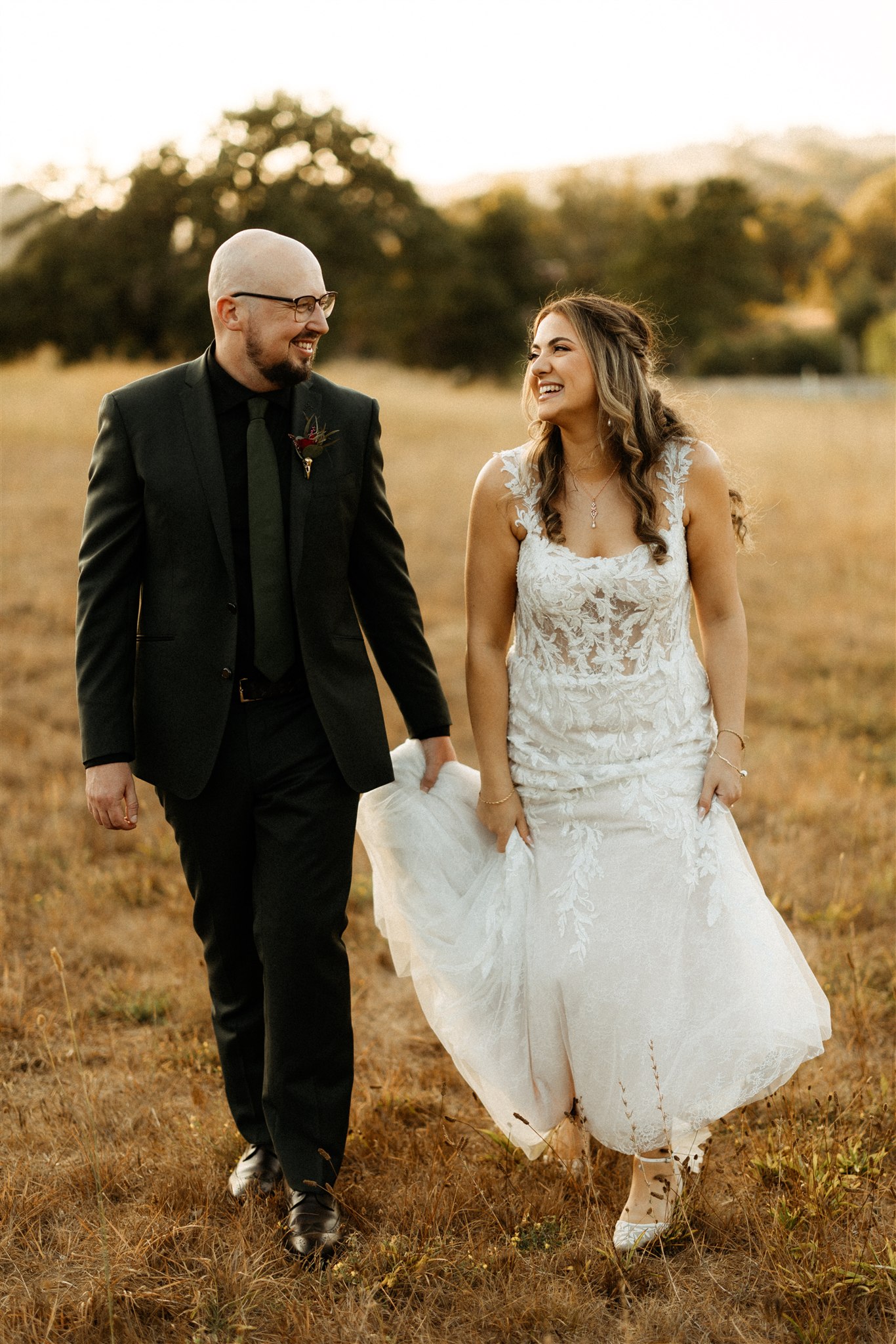 couple walking through golden light on the lawn at Mountain House Estate