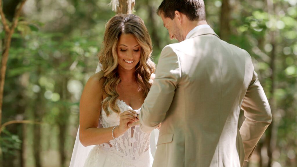 Bride smiling during the ring exchange at the Wedding in the Woods ceremony at Carolina Country Weddings