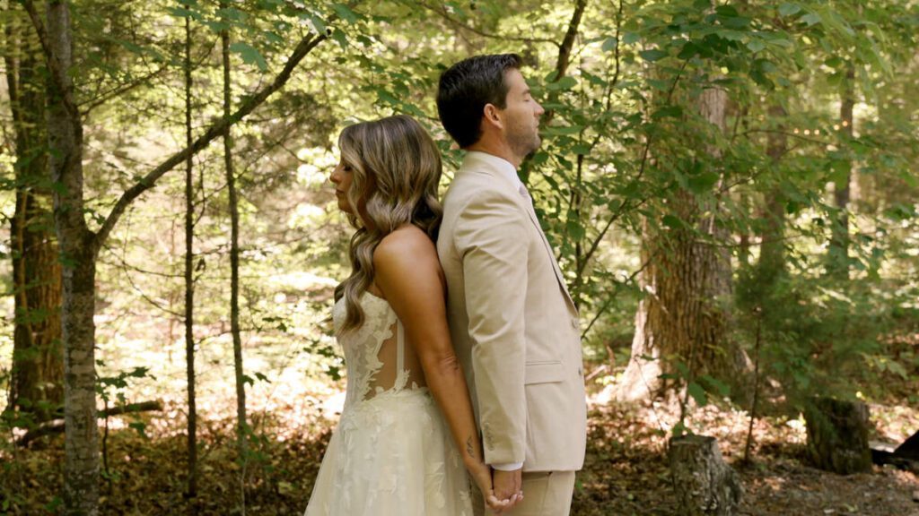 Bride and groom sharing a first touch and prayer before their Wedding in the Woods ceremony at Carolina Country Weddings