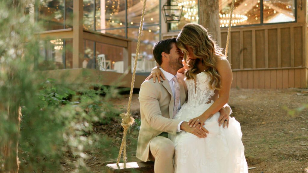 Bride and groom smiling together on a swing during portraits at Carolina Country Weddings in Mount Pleasant North Carolina