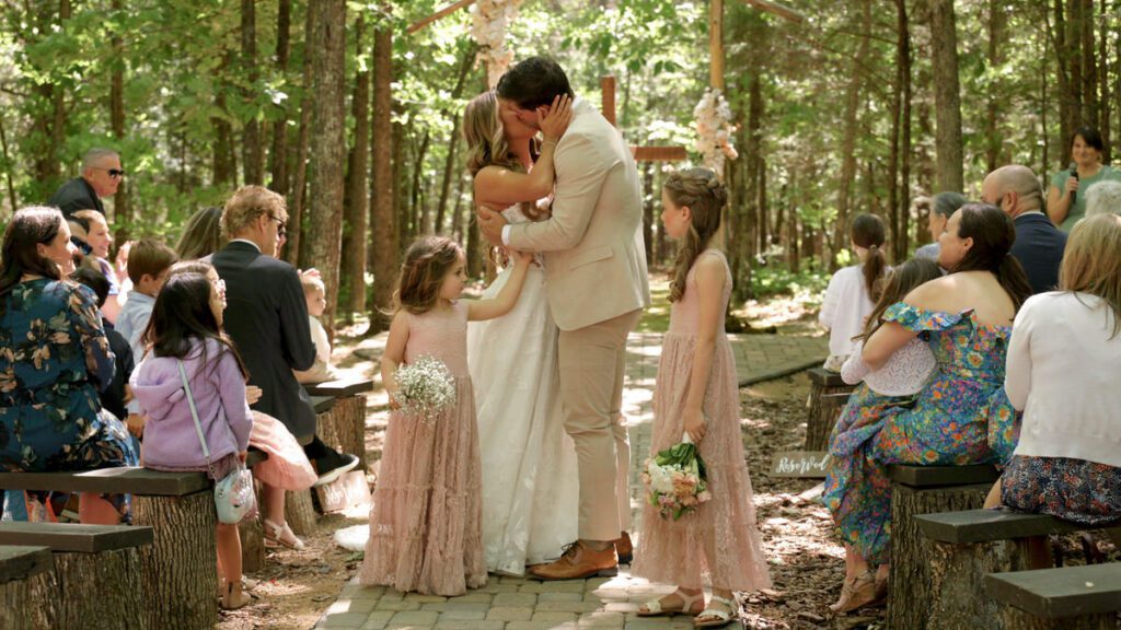 Bride and groom celebrating with a kiss after their Wedding in the Woods ceremony at Carolina Country Weddings